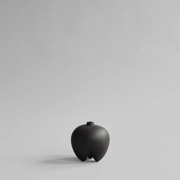Black ceramic vase on a light gray background from 101 Copenhagen at Spacio retail stores in Mumbai & Kolkata. 