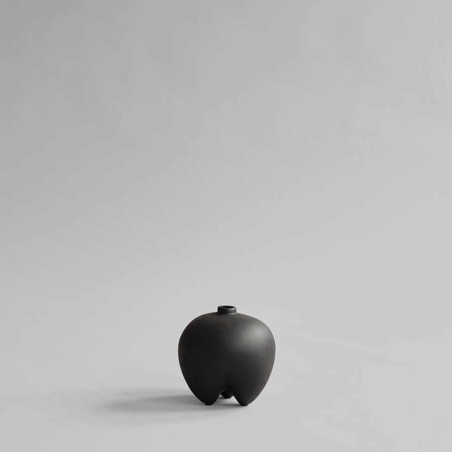 Black ceramic vase on a light gray background from 101 Copenhagen at Spacio retail stores in Mumbai & Kolkata. 
