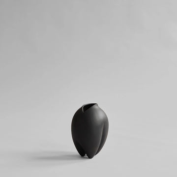 Black vase on a light gray background from 101 Copenhagen at Spacio retail stores in Mumbai & Kolkata. 