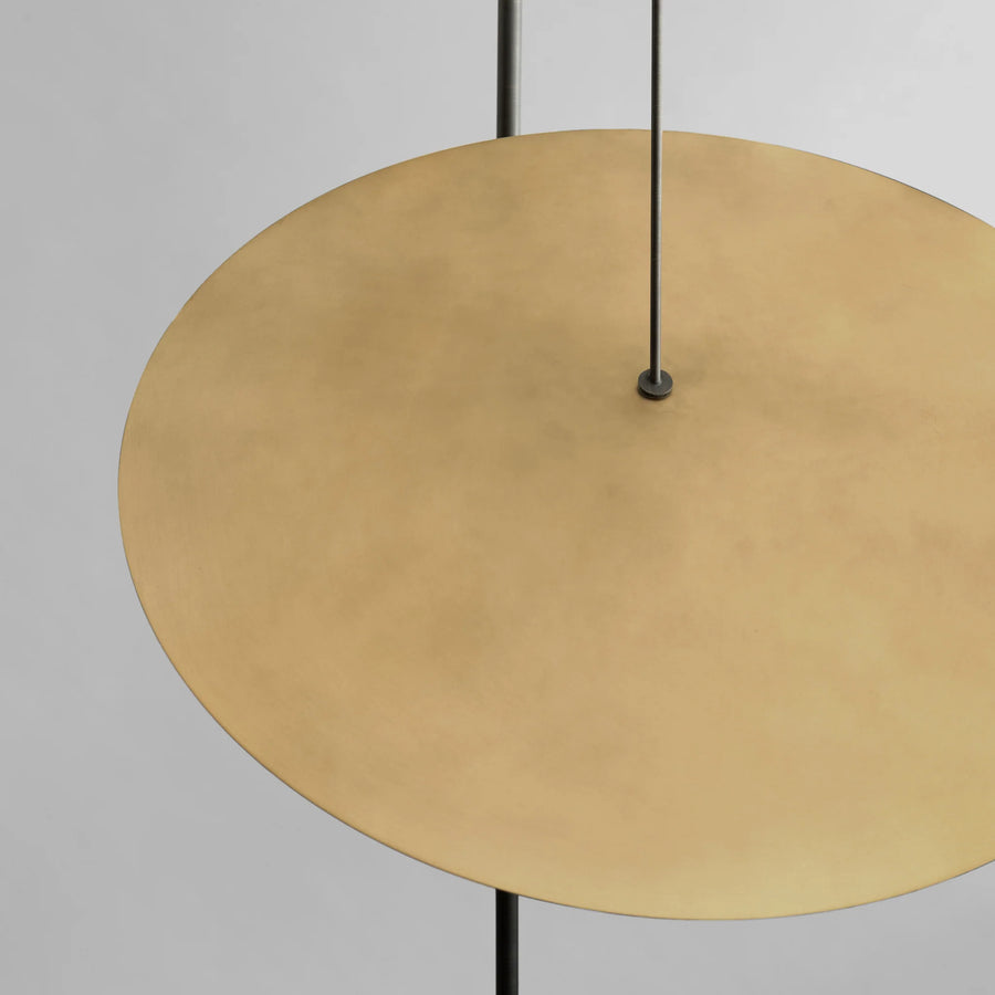 Gold circular object with black hanging cables on a gray background