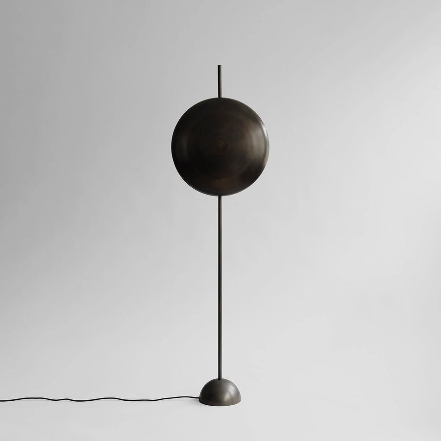 Modern floor lamp with a spherical design on a plain background