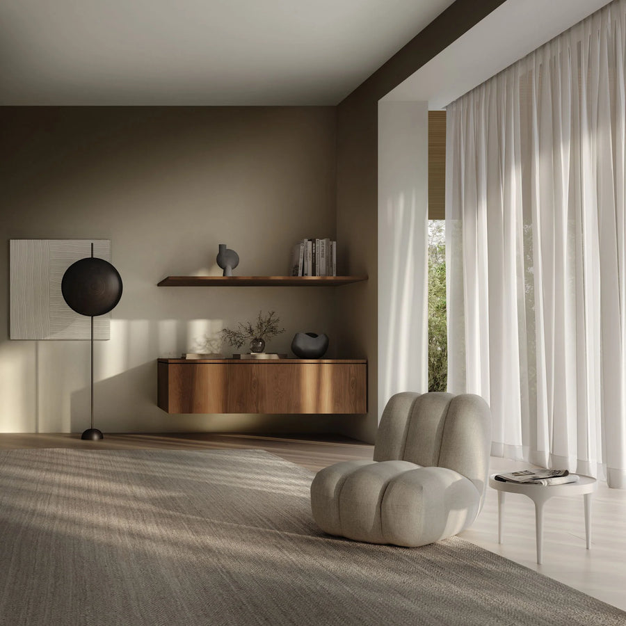 Modern living room with a wooden shelf, white armchair, and large window.