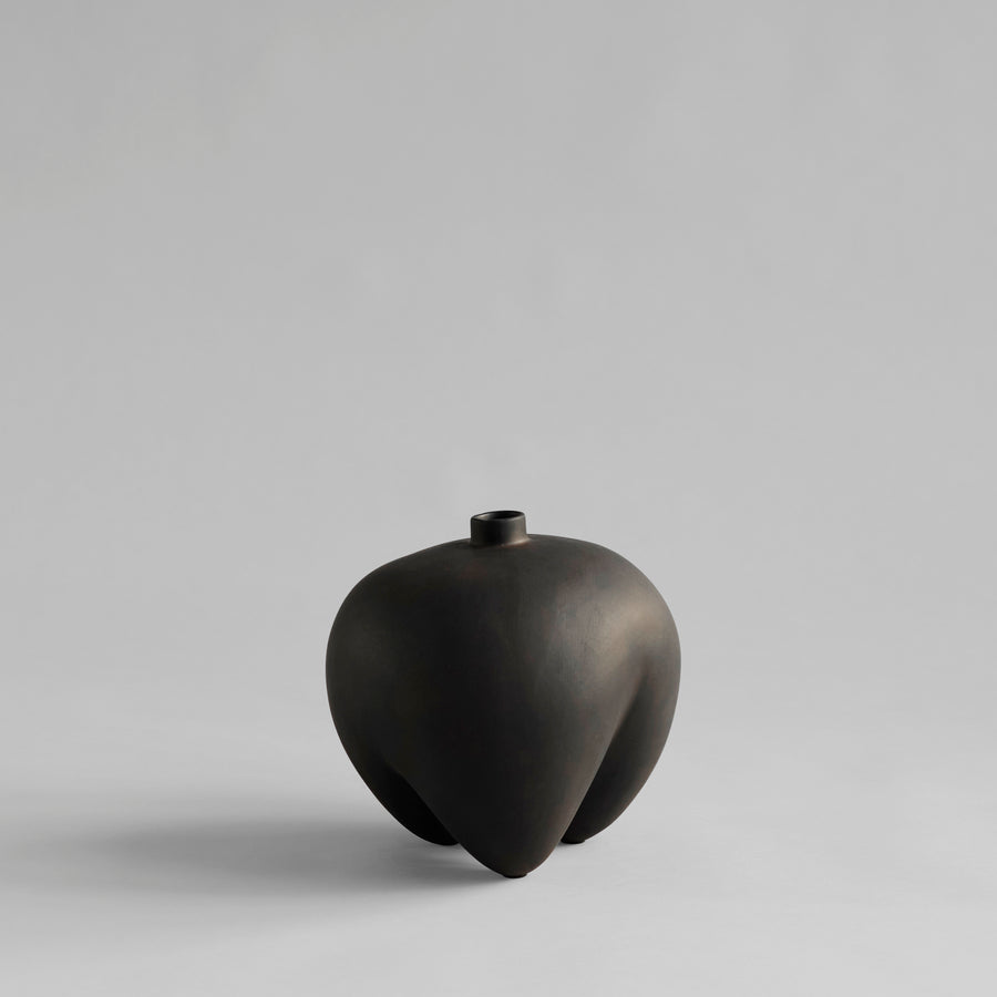 Black ceramic vase on a light gray background from 101 Copenhagen at Spacio retail stores in Mumbai & Kolkata. 