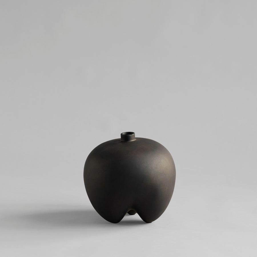 Black ceramic vase on a gray background from 101 Copenhagen at Spacio retail stores in Mumbai & Kolkata. 