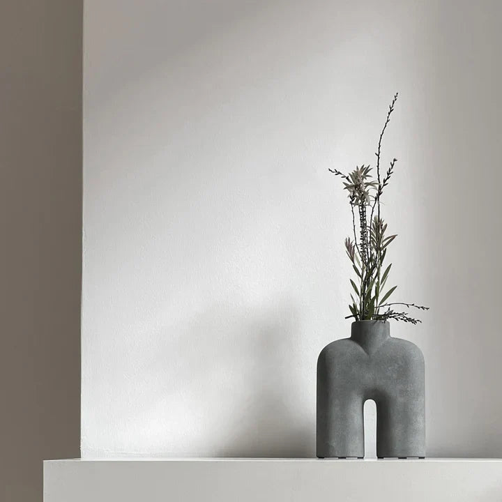 A 101Cph Cobra Tall Mini Dark Grey 211034, by 101 Copenhagen, sits on top of a white wall.