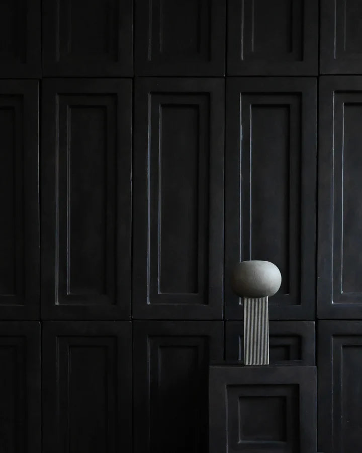 An empty room with 101Cph Empire Mini Dark Grey 223036 walls and a ceramic pedestal. (Brand Name: 101 Copenhagen)