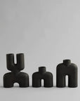 Three black 101Cph Cobra Double Mini Coffee 212002 vases on a grey background.