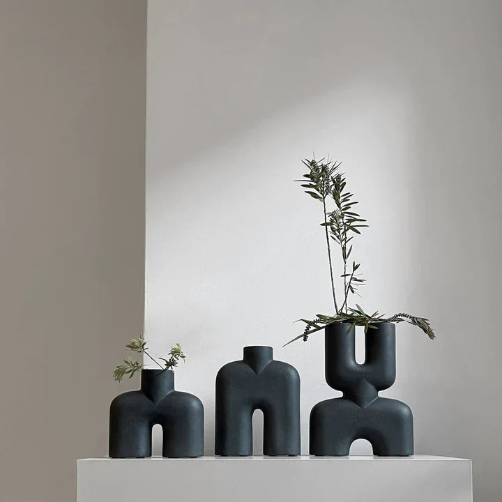 Three 101Cph Cobra Uno Mini Black 203024 vases with plants on top of them.