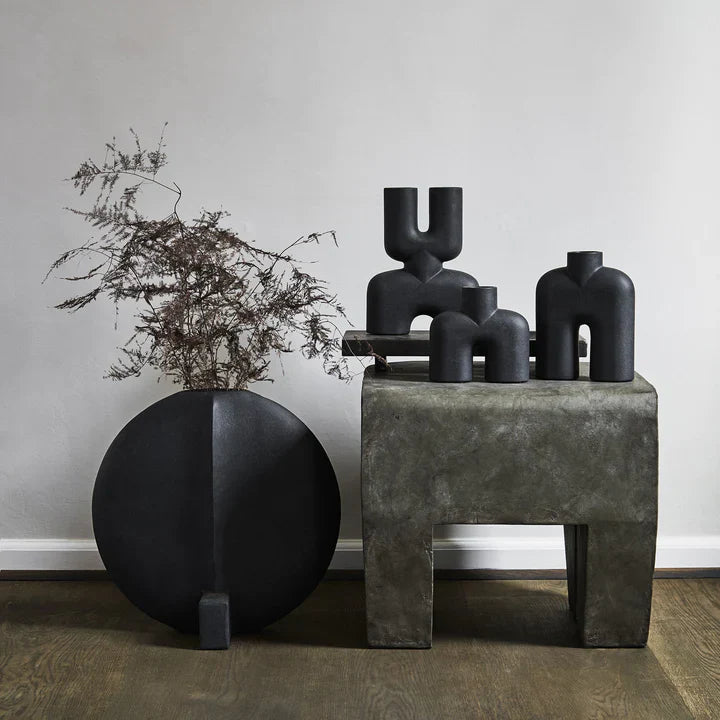A group of 101Cph Cobra Uno Mini Black 203024 vases on a table next to a plant by 101 Copenhagen.