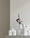 Three 101Cph Cobra Uno Mini Bubble White 203021 vases from 101 Copenhagen sit on a shelf in a room.