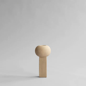 A small wooden 101Cph Empire Mini Sand 223037 on a grey background, quirky and unique in its design, reminiscent of the 101 Copenhagen Arts Movement.