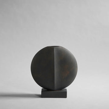 A black vase on a grey background showcasing the 101Cph Guggenheim Mini Coffee 111220 from the 101 Copenhagen Arts Movement.