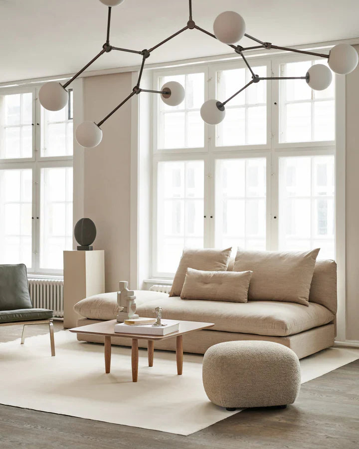 A living room with a 101Cph Guggenheim Mini Coffee 111220 couch and quirky vases. (Brand Name: 101 Copenhagen)