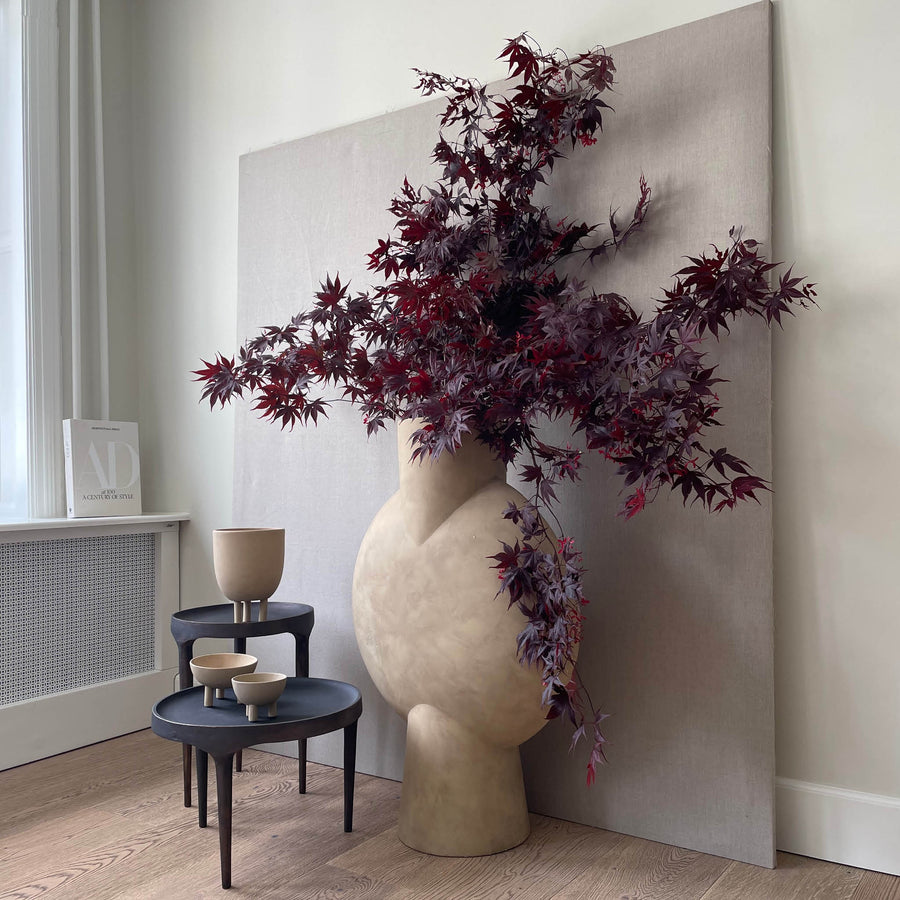 Decorative vase with purple leaves against a neutral wall along with bowls from 101 Copenhagen