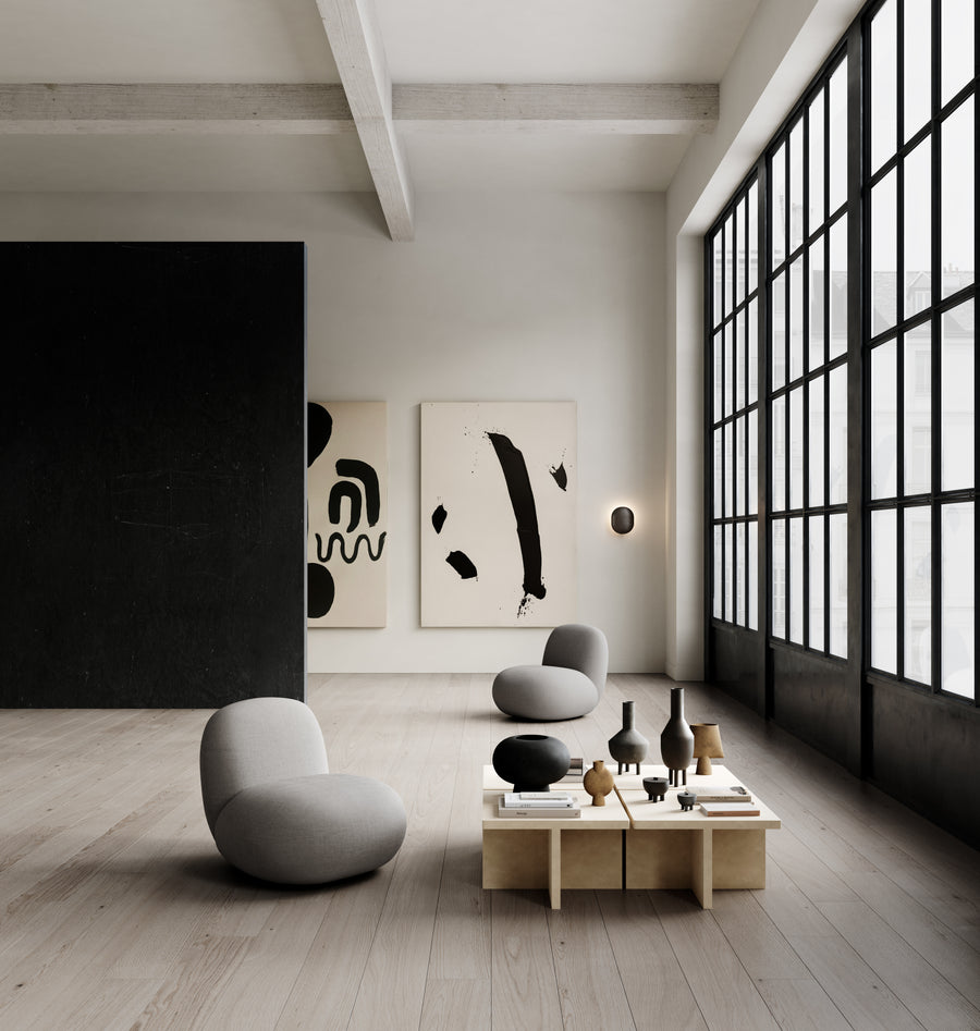 Modern living room with minimalistic decor, abstract art, and a large window.