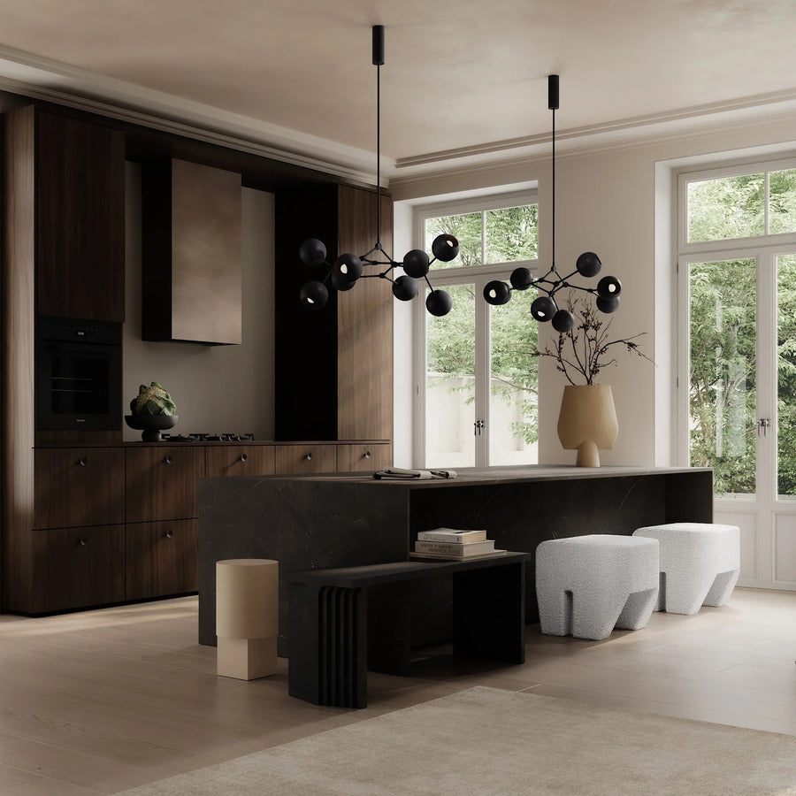 Modern living room with dark wood furniture, white stools, and decorative lighting.