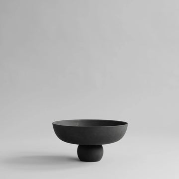 Black ceramic bowl on a light gray background from 101 Copenhagen at Spacio retail stores in Mumbai & Kolkata. 