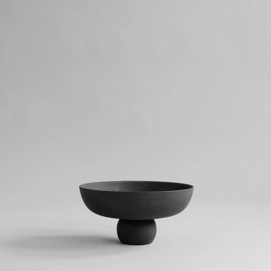 Black ceramic bowl on a light gray background from 101 Copenhagen at Spacio retail stores in Mumbai & Kolkata. 