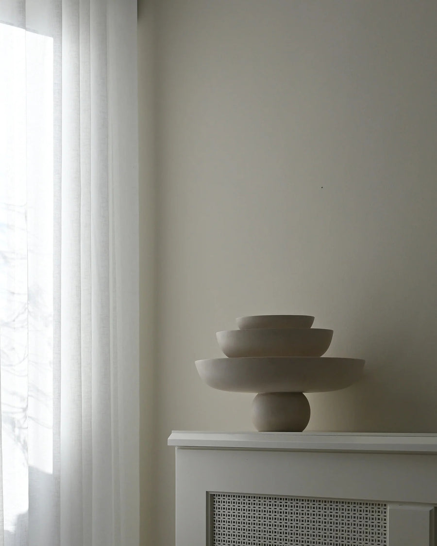 Three ceramic bowls on a white surface with a neutral wall and window in the background from 101 Copenhagen at Spacio retail stores in Mumbai & Kolkata. 