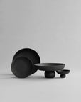 Set of black ceramic bowls on a light gray background from 101 Copenhagen at Spacio retail stores in Mumbai & Kolkata. 