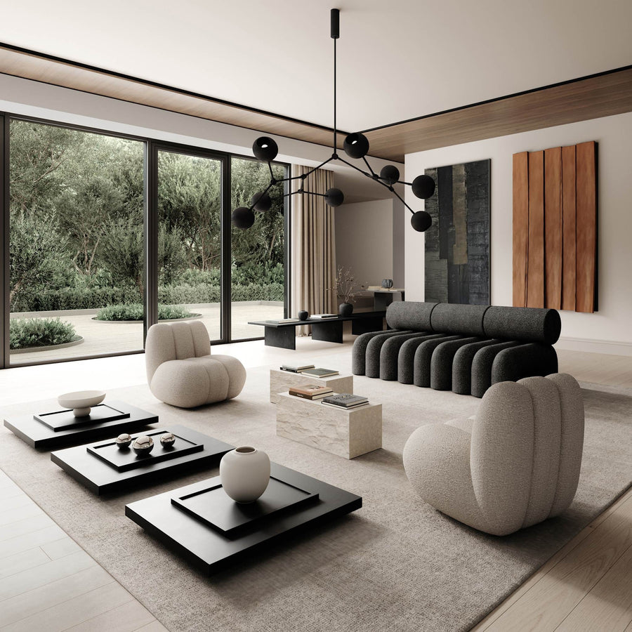 Modern living room with gray sofa, white chairs, and black coffee tables.