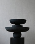 Stack of black ceramic bowls on a gray background from 101 Copenhagen at Spacio retail stores in Mumbai & Kolkata. 