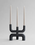 A minimalistic 101Cph Cobra Candle Holder Black 223071 by 101 Copenhagen showcasing silhouettes with three candles.