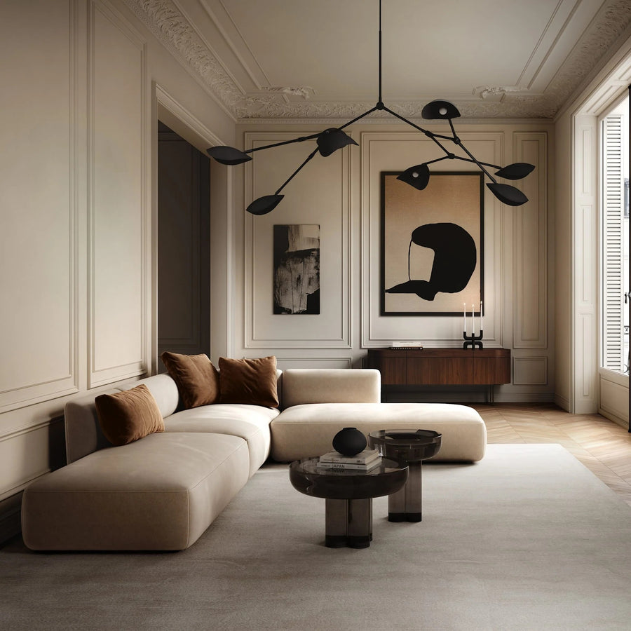 Modern living room with a beige sectional sofa, round coffee table, and decorative wall art.
