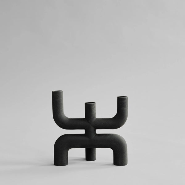 Black abstract candle holder on a light gray background from 101 Copenhagen at Spacio retail stores in Mumbai & Kolkata. 