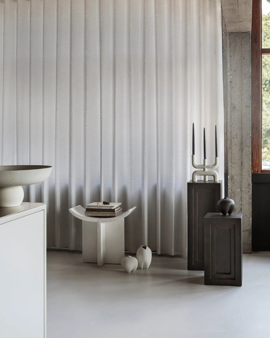 Modern interior with a curtain, side table, and decorative items from 101 Copenhagen at Spacio retail stores in Mumbai & Kolkata. 