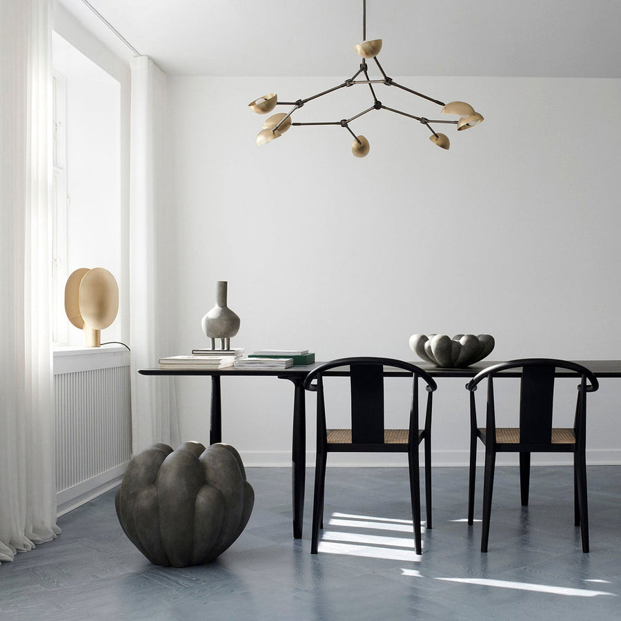 A dining room with a 101Cph Duck Fat Dark Grey 111281 table and chairs in dark grey colour by 101 Copenhagen.