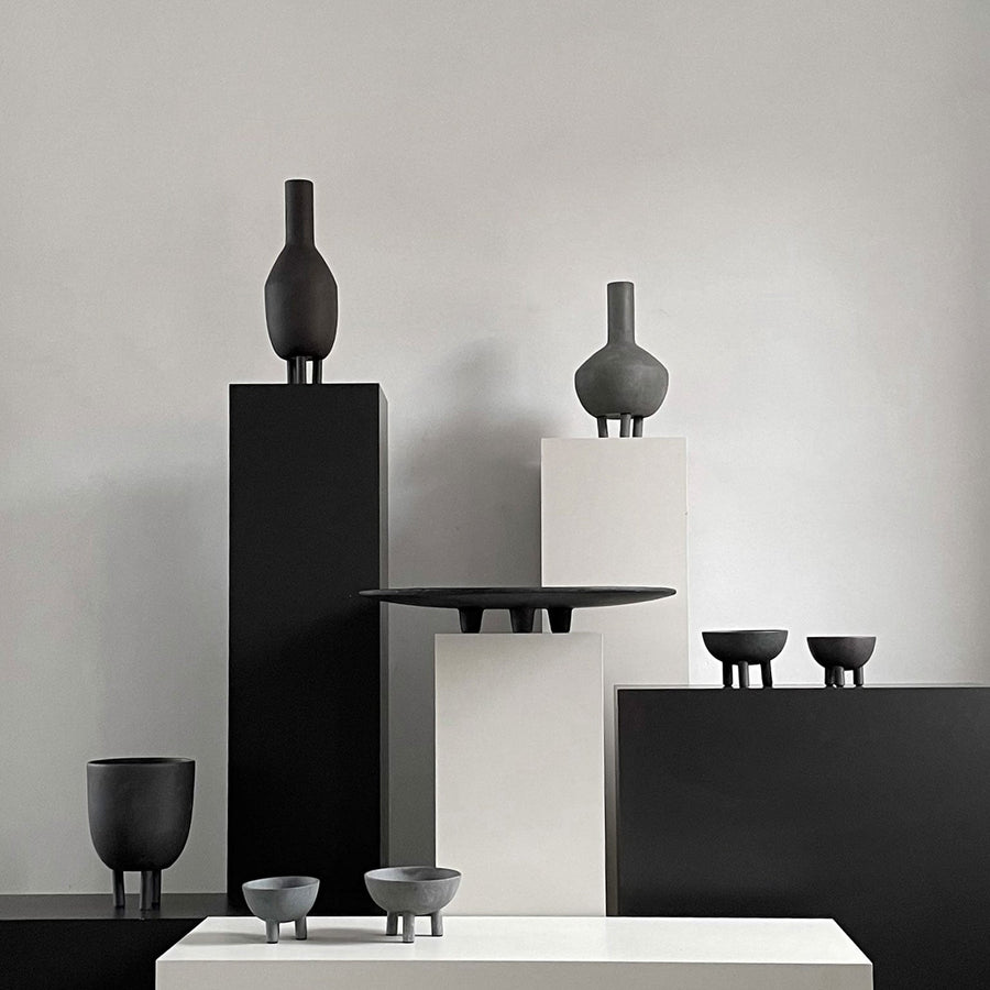 A group of 101Cph Duck Fat Dark Grey 111281 vases by 101 Copenhagen on a table.