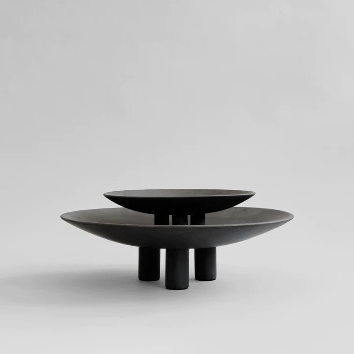 Two 101Cph Duck Plate Big Coffee 214049 black bowls, inspired by Scandinavian home decor, sitting on top of each other.