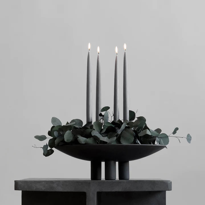 A minimalist black 101Cph Duck Plate Big Coffee 214049 candle holder featuring delicate eucalyptus leaves on top, perfect for a Scandinavian home.