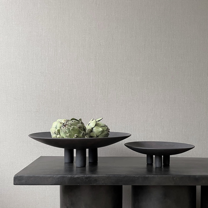 Two black 101Cph Duck Plate Mini Coffee 214048 bowls on a table next to each other in a Scandinavian home by 101 Copenhagen.
