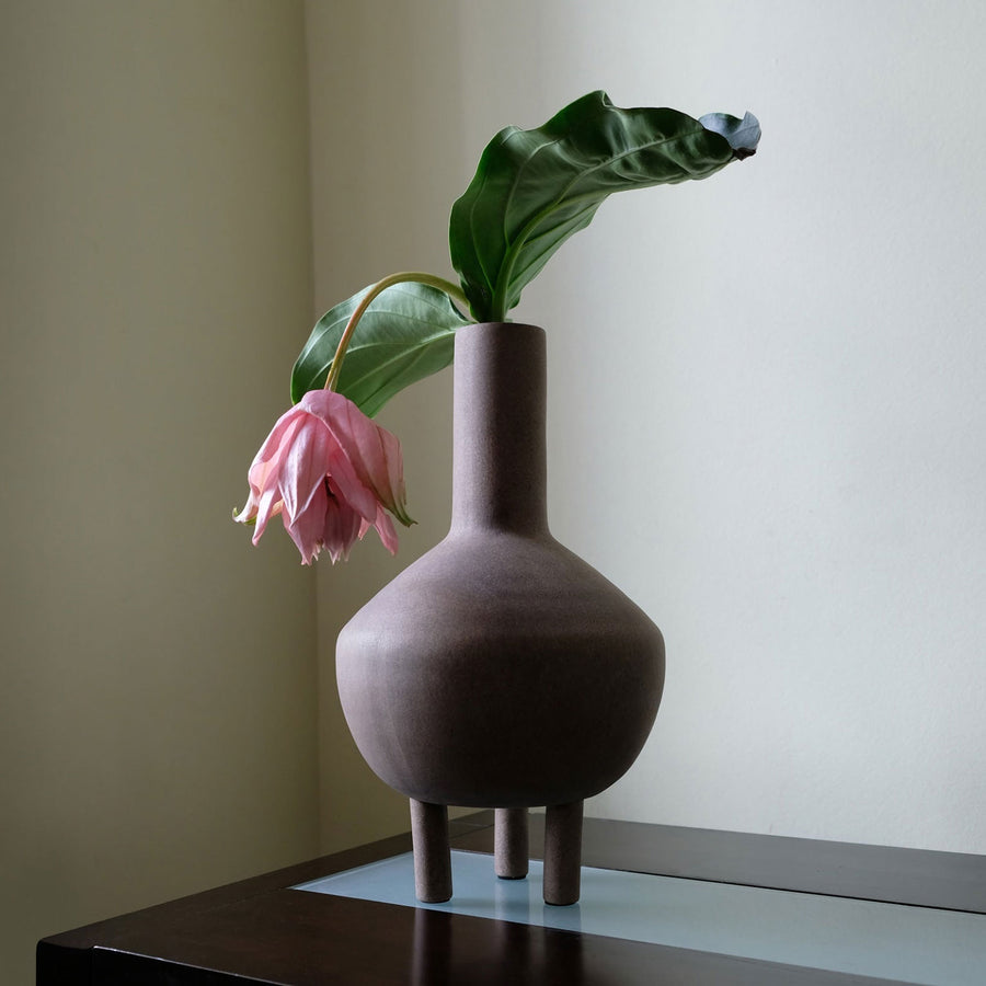 A quirky 101Cph Duck Vase Fat Taupe 213045 with a pink flower in it.