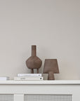 A shelf with books and 101Cph Duck Vase Fat Taupe 213045 by 101 Copenhagen on it.