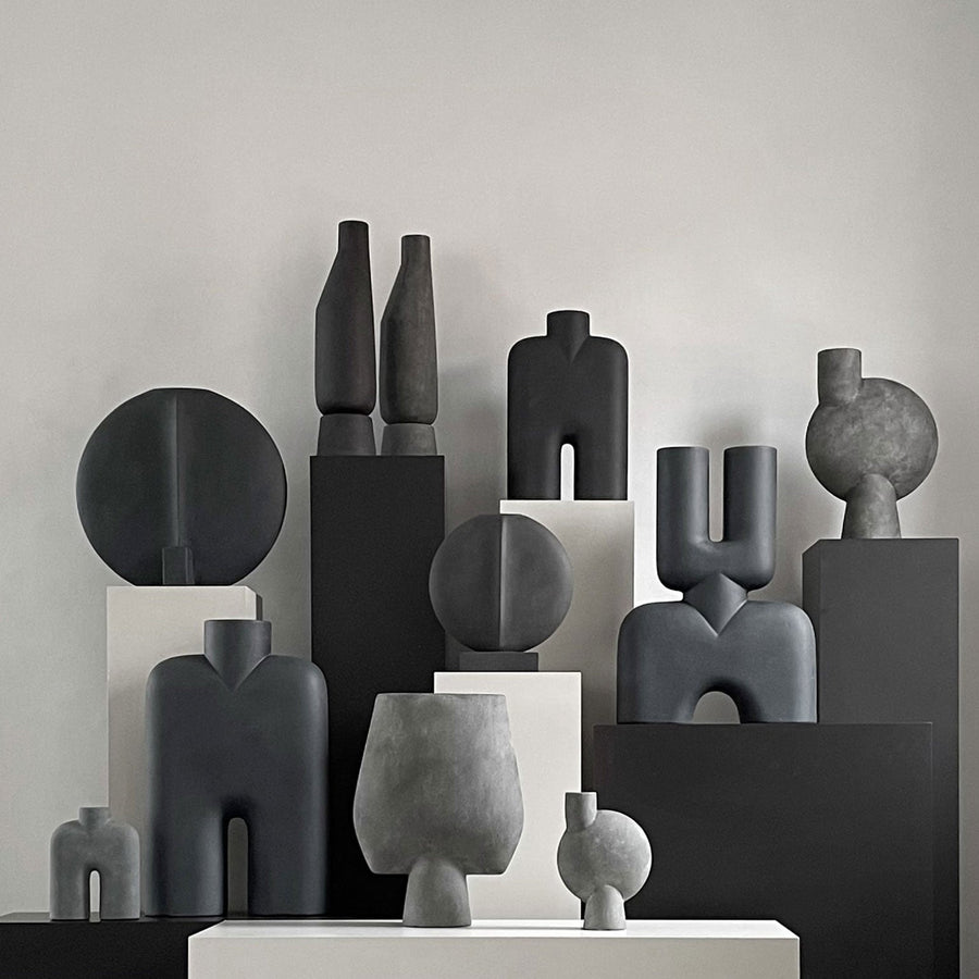 A group of black and white 101Cph Guggenheim Big Coffee 111219 vases by 101 Copenhagen on a table.