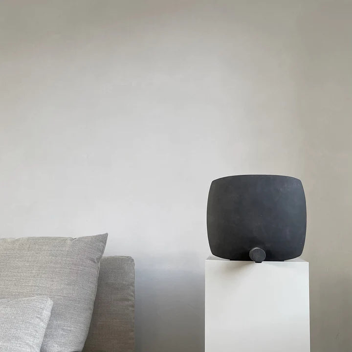 A handcrafted 101Cph Guggenheim Square Coffee 111124 vase sits on top of a pedestal in a room.