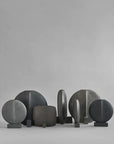 A group of 101 Copenhagen Guggenheim Square Coffee 111124 handcrafted black and grey sculptures on a grey background.