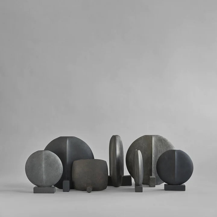 A group of 101 Copenhagen Guggenheim Square Coffee 111124 handcrafted black and grey sculptures on a grey background.