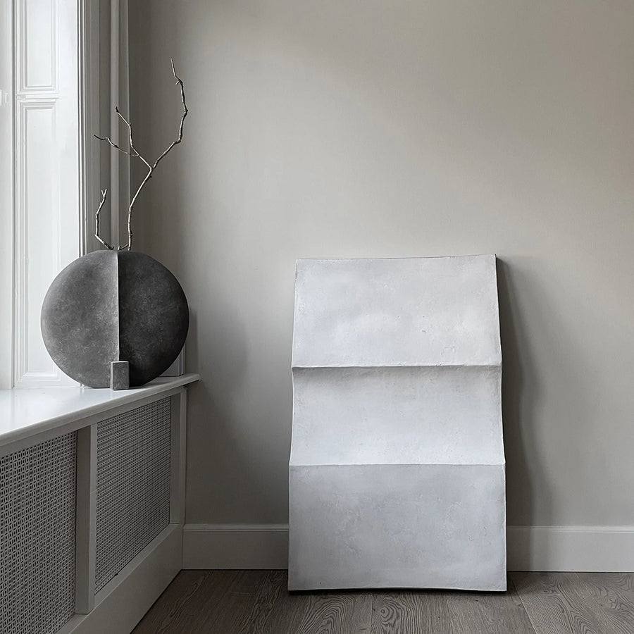 Modern interior with a grey ceramic vase from 101 Copenhagen and a concrete wall art piece.