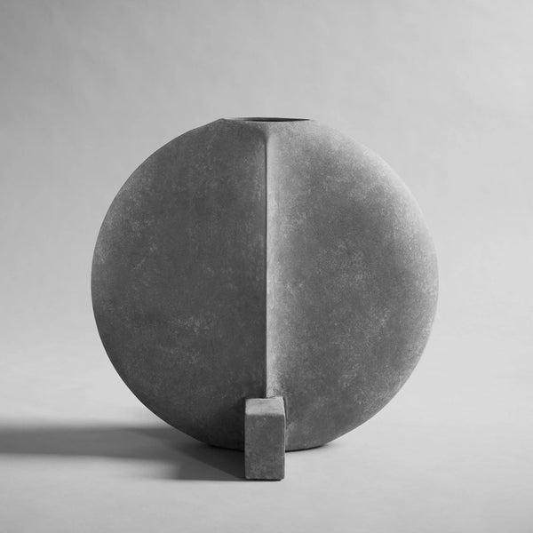 Gray sculptural vase with a geometric design on a gray background from 101 Copenhagen at Spacio retail stores in Mumbai & Kolkata. 