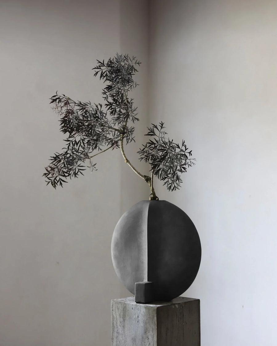 Decorative vase with a branch on a neutral background from 101 Copenhagen at Spacio retail stores in Mumbai & Kolkata. 