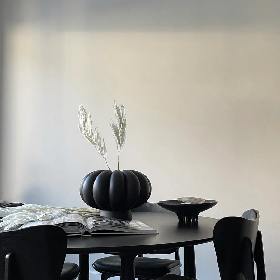 A 101Cph Medusa Tray Mini Coffee 221064 with black chairs and a ceramic pumpkin vase.