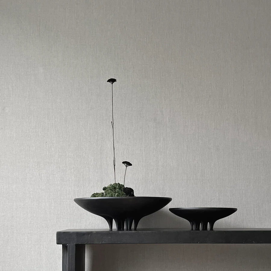 The 101Cph Medusa Tray Mini Coffee 221064, made of ceramic, holds two black bowls on a table next to a wall.