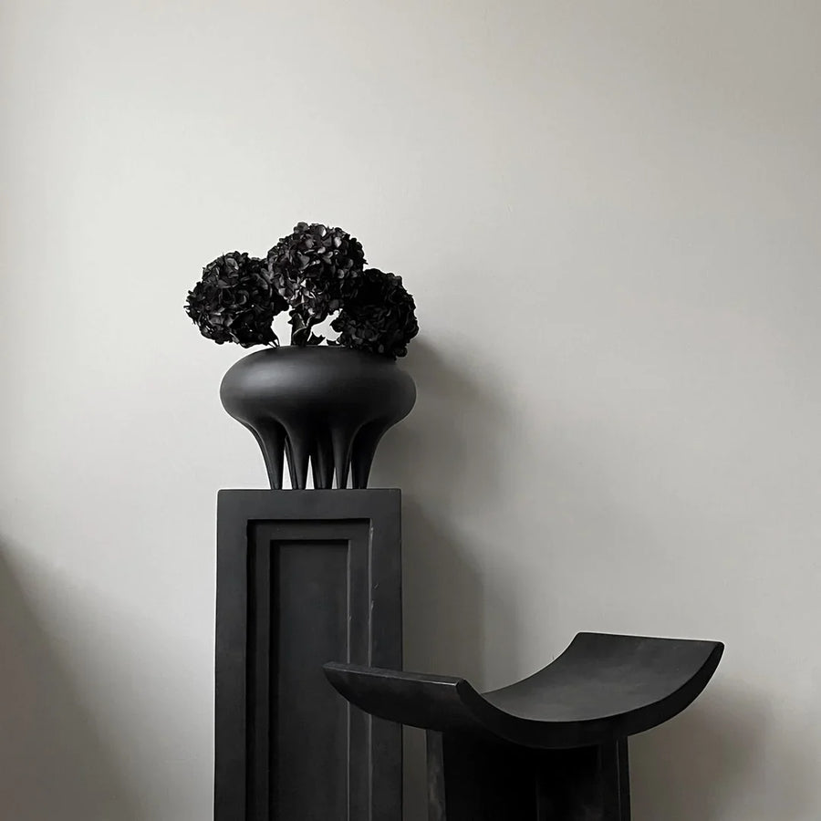 A 101 Copenhagen Medusa Vase Big Coffee 221061 sits on top of a black pedestal.