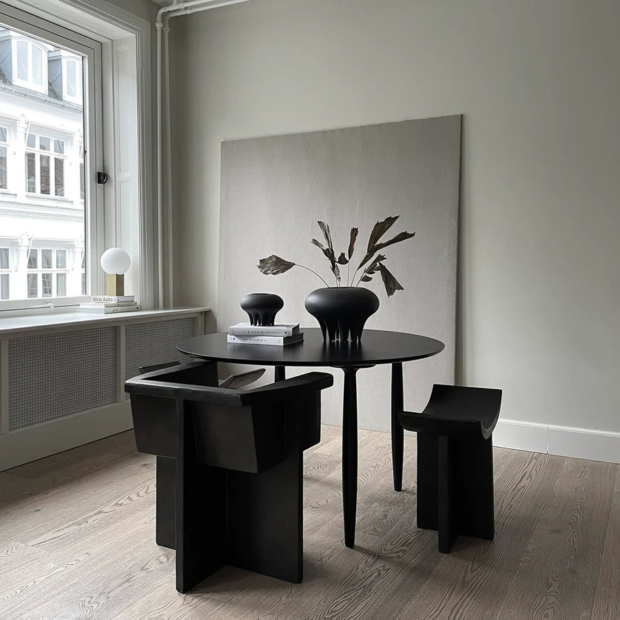 A dining room with a black table and chairs adorned with a 101 Copenhagen Medusa Vase Big Coffee 221061.