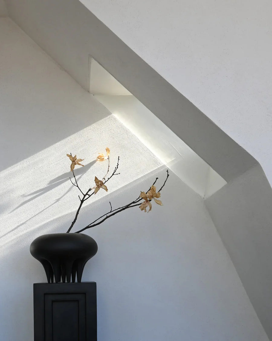 A 101Cph Medusa Vase Big Coffee 221061 from 101 Copenhagen sits on top of an attic window.