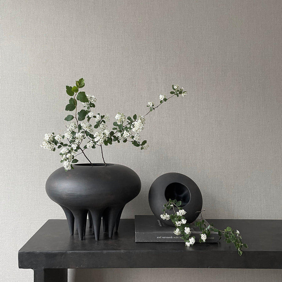 A 101Cph Medusa Vase Big Coffee 221061 by 101 Copenhagen with white flowers on a table.